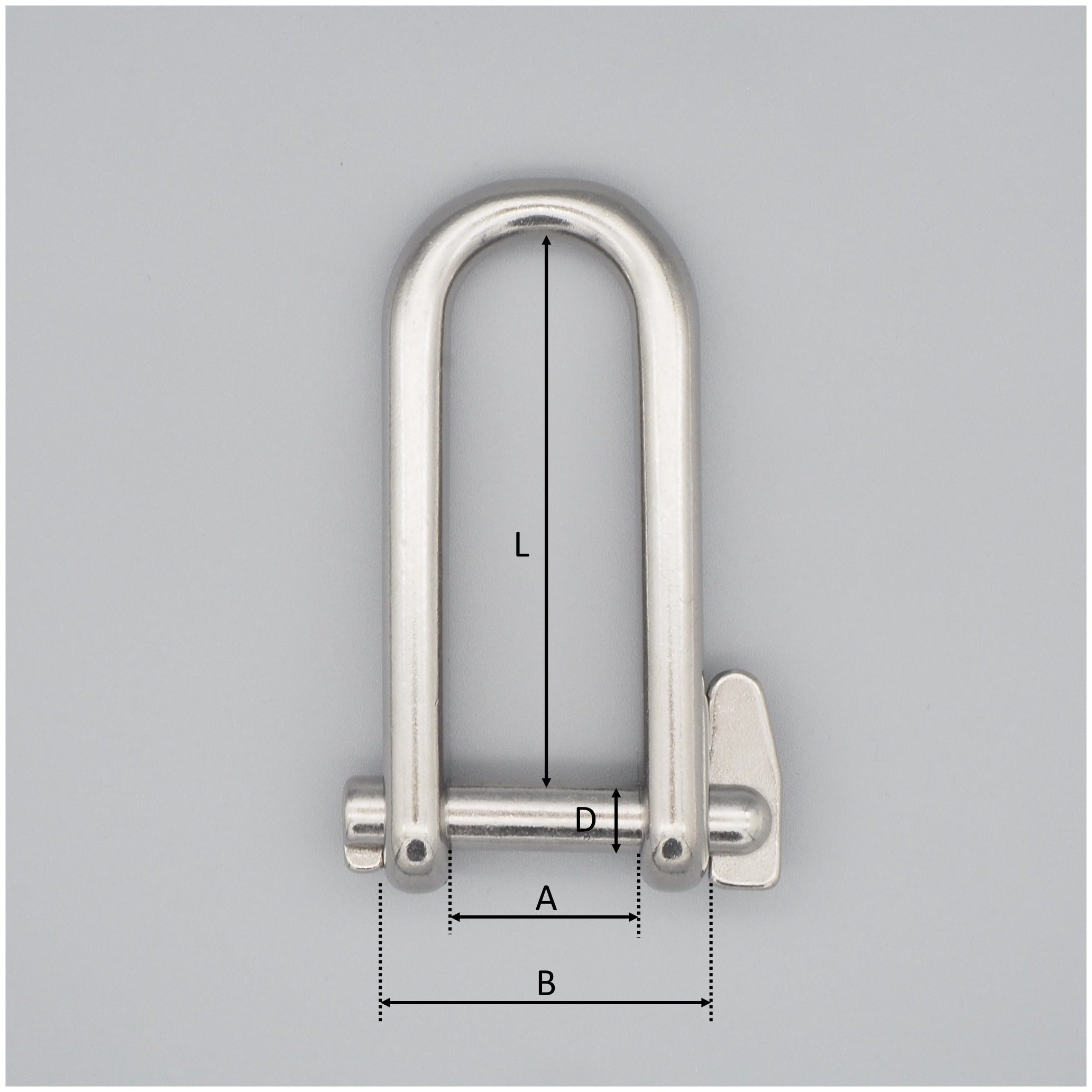 Rostfri nyckelschackel mot en grå bakgrund som är måttsatt.